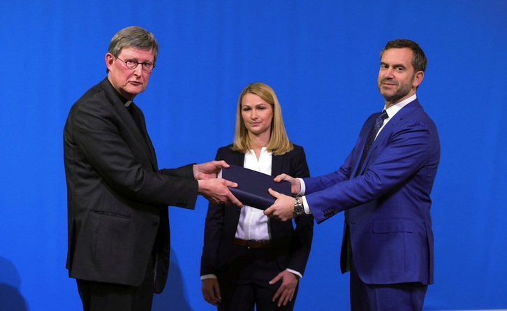 El abogado Bjoern Gercke, a la derecha, entrega al arzobispo de Colonia Rainer Maria Woelki un informe sobre abusos por parte del clero. (Ina FASSBENDER/AFP) 
