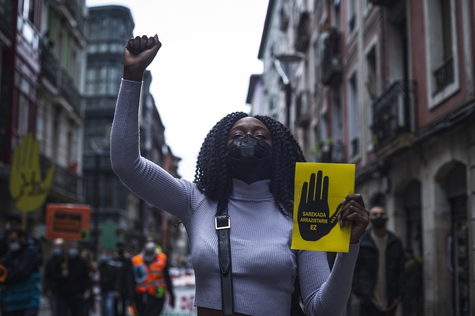 Una mujer porta un cartel contra las redadas racistas. (Aritz LOIOLA/FOKU)