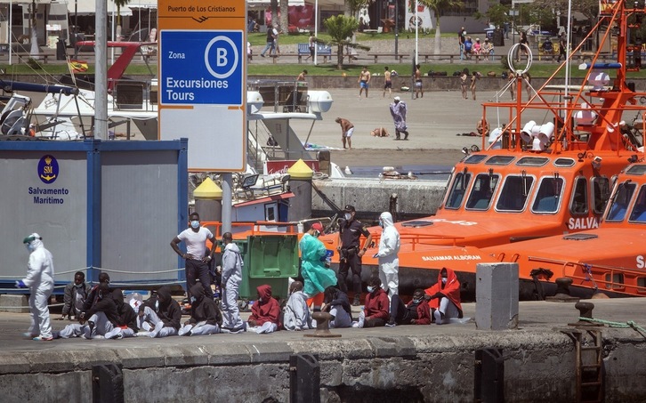 Varios migrantes son atendidos en un puerto de Tenerife por los servicios sanitarios tras ser rescatados. (Desiree MARTIN/AFP) 