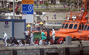 Varios migrantes son atendidos en un puerto de Tenerife por los servicios sanitarios tras ser rescatados. (Desiree MARTIN/AFP) 