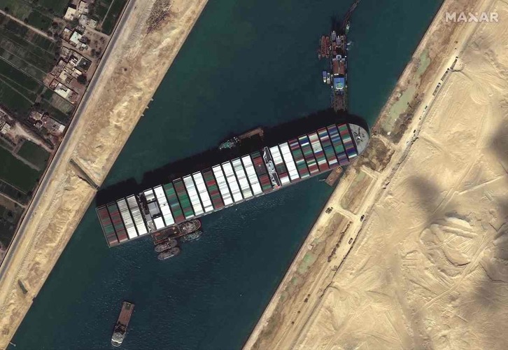 Remolcadores y dragas trabajan para desencallar el carguero Ever Given en el Canal de Suez. (AFP)