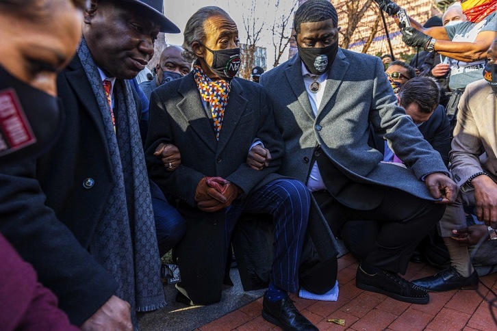 La familia de George Floyd se arrodilla junto a su abogado ante el juzgado donde se juzga al responsable de su muerte. (Kerem YUCEL/AFP) 