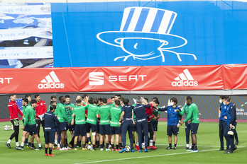 Los jugadores y los técnicos de la Real, antes del entrenamiento en el fondo en el que aparece la figura que recuerda a Aitor Zabaleta. (Monika DEL VALLE/FOKU)