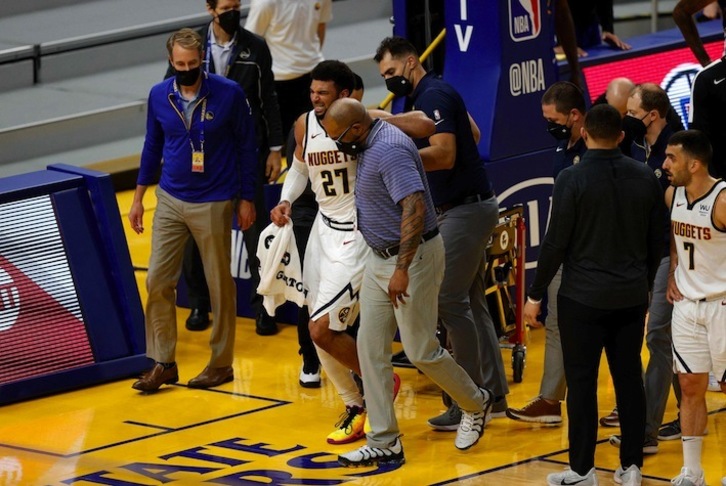 Jamal Murray se retira a la pata coja después de lesionarse gravemente la rodilla ante los Golden State Warriors. (Ezra SHAW / AFP PHOTO)