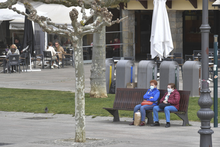 Dos personas descansan en un banco de la Plaza del Castillo.      (Idoia ZABALETA I FOKU)