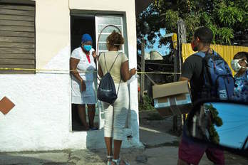 Sanitarios visitan una zona acordonada de La Habana por presencia de coronavirus. (Yamil LAGE/AFP)
