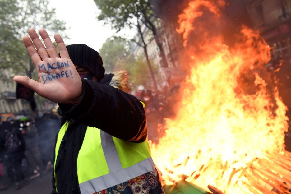 Manifestari bat Parisen, esku-ahurrean ‘Macron kanpora’ idatzita. (Bertrand GUAY/AFP)