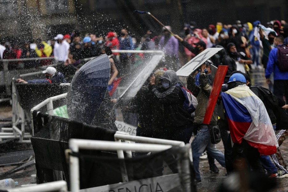 Un grupo de manifestantes se protegen ante una carga policial en Colombia. (Europa Press)