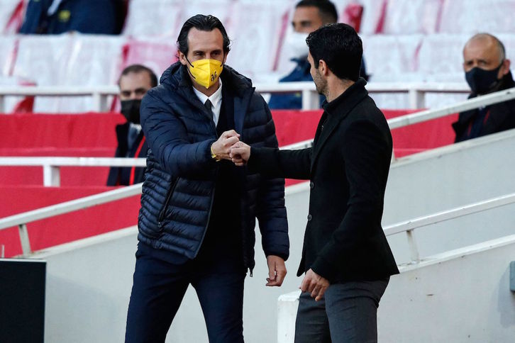 Los técnicos vascos Unai Emery y Mikel Arteta se saludan antes del Arsenal-Villarreal de Europa League. (Adrian DENNIS/AFP)