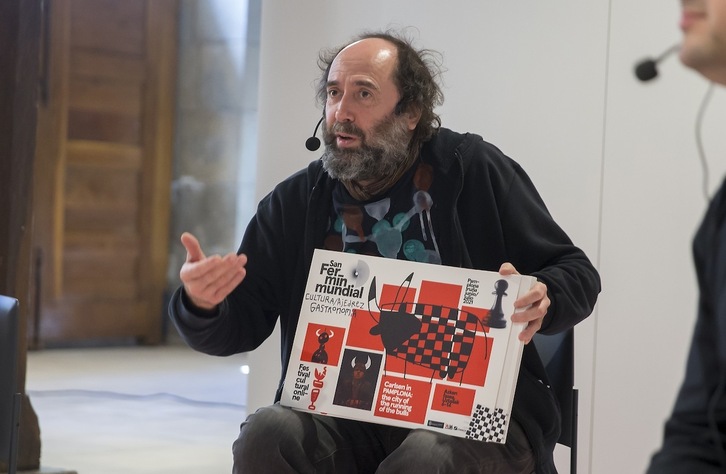 MIkel Urmeneta explica uno de los carteles que ha diseñado para el festival online ‘La Fiesta Inteligente’. (AYUNTAMIENTO DE IRUÑEA)