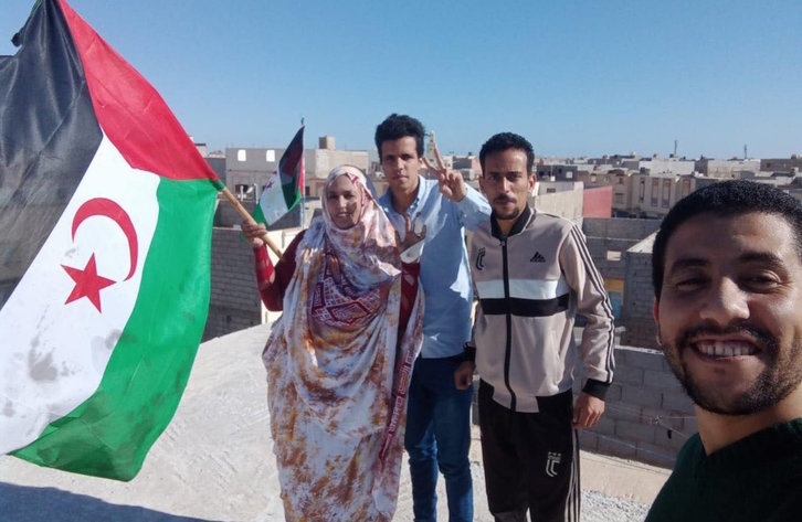 Los activistas, en casa de Sultana Jaya, con la bandera saharaui. (@SAHARAWIVOICE) 