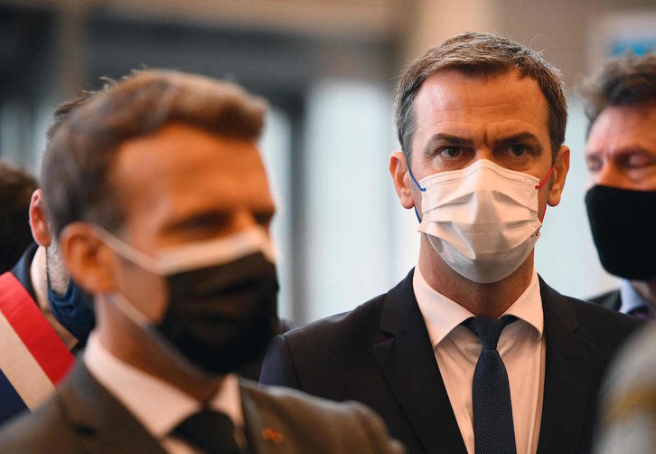 El ministro de Sanidad, Olivier Véran, durante una visita de Emmanuel Macron al centro de vacunación de Versailles, el 6 de mayo. (Christophe ARCHAMBAULT/AFP)