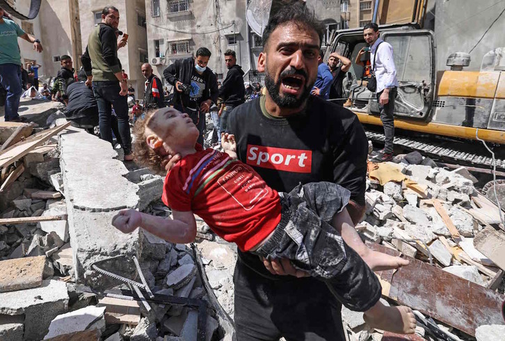 Un palestino grita tras encontrar el cuerpo de una niña entre los escombros de un edificio bombardeado por Israel en Gaza. (Mahmud HAMS/AFP)
