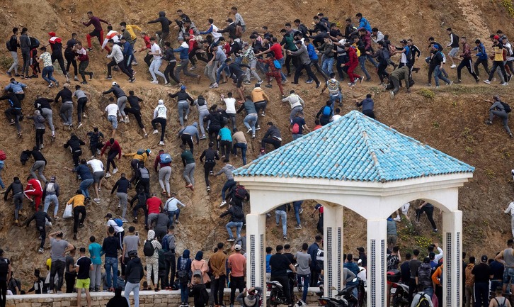 Migrantes evitan a la Policía marroquí mientras intentan llegar a Ceuta. (Fadel SENNA/AFP)