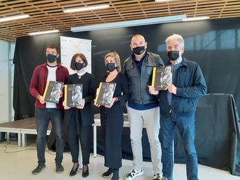 Aurkezpenean parte hartu duten kideak liburua erakusten (Asier AIESTARAN)