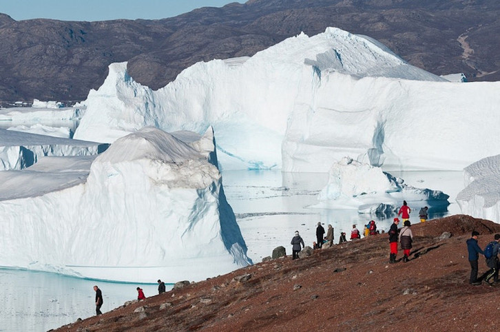 Turistas en Groenlandia en primer plano con un glaciar al fondo. (OCEANWIDE)