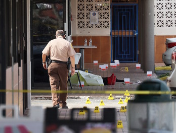 Un policía camina junto a cuerpo de unas de las víctimas mortales de Hialeah. (Joe RAEDLE/GETTY IMAGES/AFP)