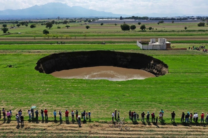 Cientos de personas se han acercado a la zona del hundimiento pese a las llamadas a la prudencia. (Jose CASTAÑARES | AFP)