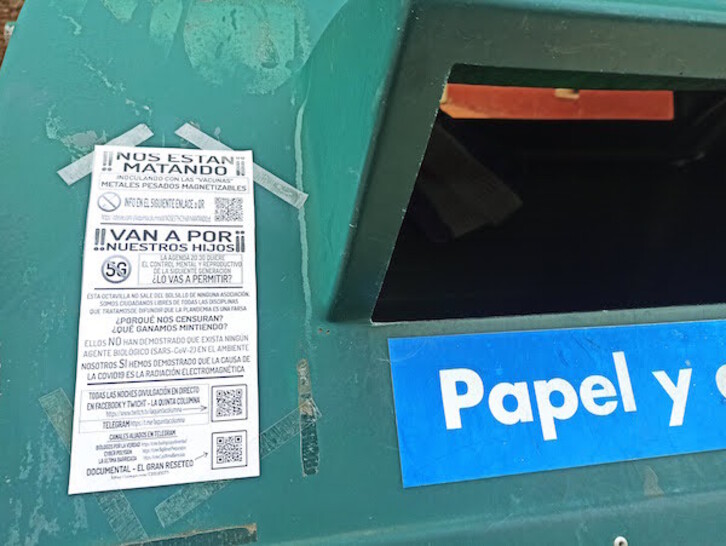 Cartel de un grupo negacionista en un  contenedor de papel de la Mancomunidad de Mairaga.
