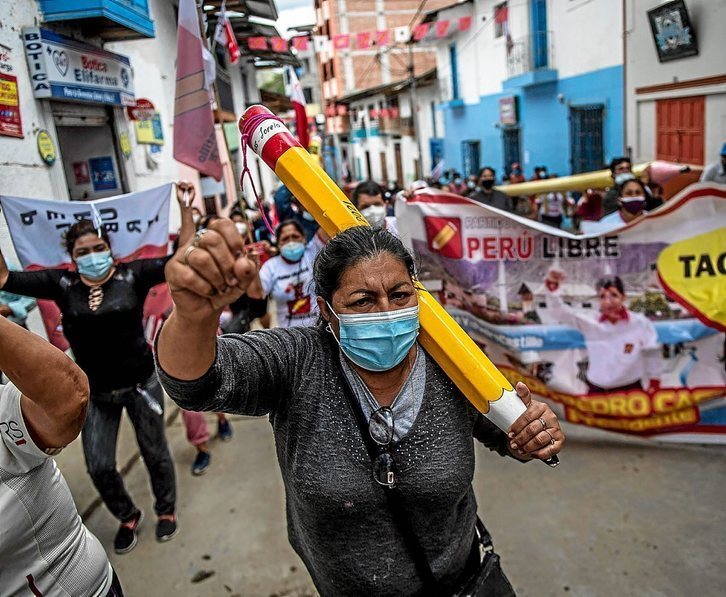 Seguidores de Castillo con un lápiz, símbolo del partido Perú Libre, celebran la ventaja en el recuento en su pueblo natal, Tacabamba. (Ernesto BENAVIDES /AFP)