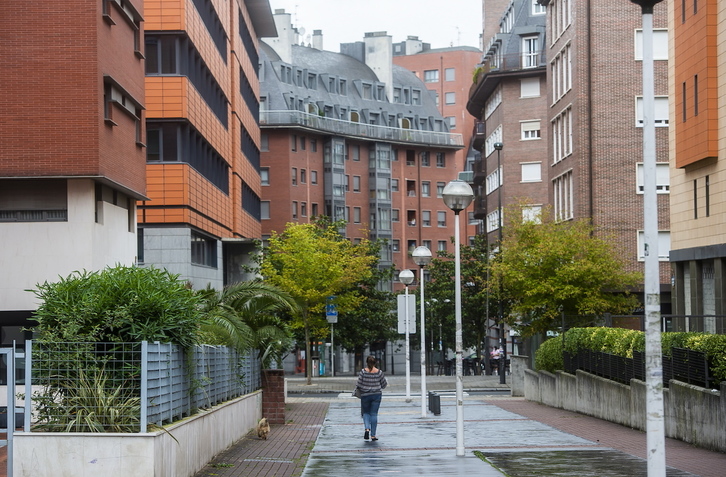 Una mujer camina entre los edificios del barrio de Miribilla, en Bilbo. (Luis JAUREGIALTZO/FOKU)