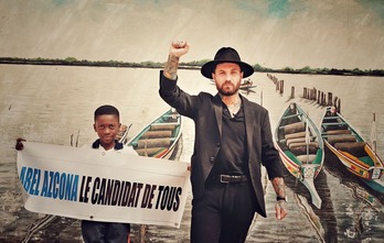 Abel Azcona con un niño portando el cartel que el artista usó en el polémico mitin artístico. (NAIZ)