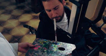 El artista Leonardo Portella manejando el pincel con la boca. (NAIZ)