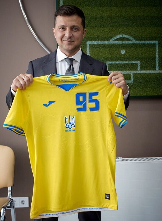 El presidente ucraniano Volodymyr Zelensky posa con la camiseta original de la selección de Ucrania. (AFP)