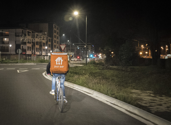 Un repartidor en bicicleta trabajando por la noche para la empresa Just Eat. (Gorka RUBIO/FOKU)