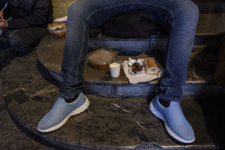Un joven sin techo recibe alimento por parte de voluntarios en Donostia.(Jon URBE/FOKU)