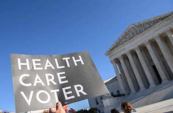 Un manifestante pide ante el Supremo que se respete la reforma de Obama. (Nicholas KAMN/AFP)