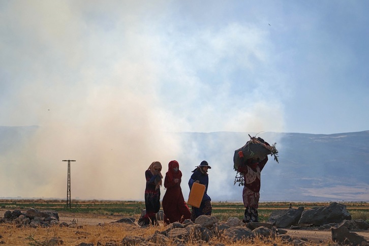 Mujeres caminando cerca de Az Ziyarah, en la provincia de Hama, tras un bombardeo del Ejército sirio el pasado el 6 de junio. (Abdulaziz KETAZ/AFP)
