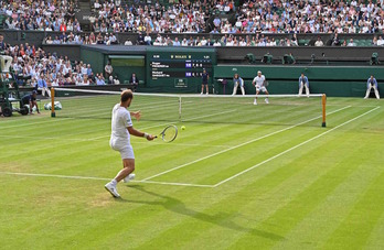 Gasquet se dispone a golpear la pelota ante un atento Federer en Wimbledon. (Glyn KIRK/AFP)