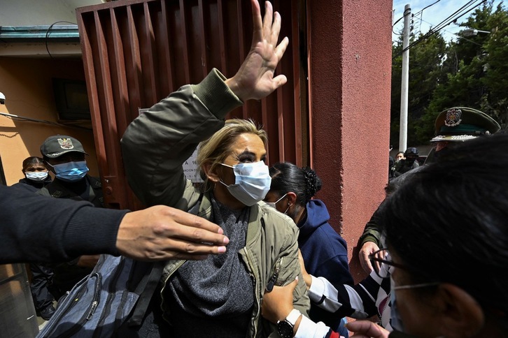 En esta imagen tomada el pasado 15 de marzo, Jeanine Áñez, que se proclamó presidenta tras el golpe, saluda mientras es escoltada por la Policía camino de la cárcel de Obrajes, en La Paz. (Aizar RALDES | AFP)