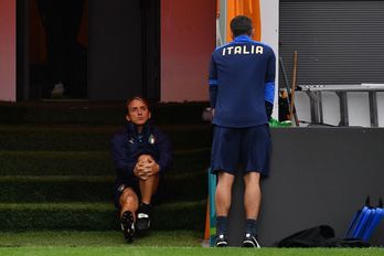 Mancini conversa con uno de sus ayudantes en el entrenamiento previo al duelo de semifinales frente a España. (Justin TALLIS / AFP)