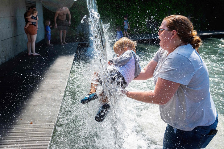 Una madre intenta refrescar a un niño de las sofocantes temperaturas en Washington. (Jim WATSON | AFP)