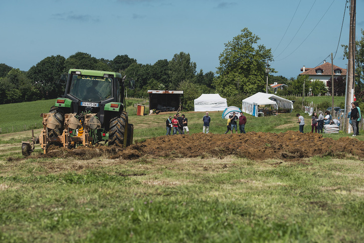 Traktorearen laguntzaz lurra irauli eta baratzea sortzeko eremua prestatu dute gaur goizean Arbonako lursail okupatuan. (Guillaume FAUVEAU)