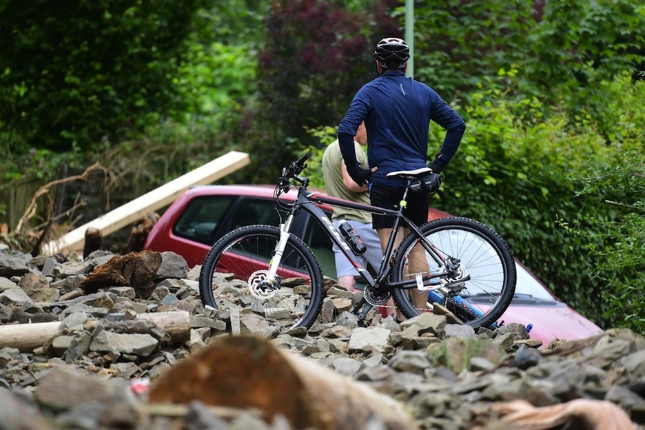 Un ciclista observa los restos de una edificación. (Ina FASSBENDER/AFP)