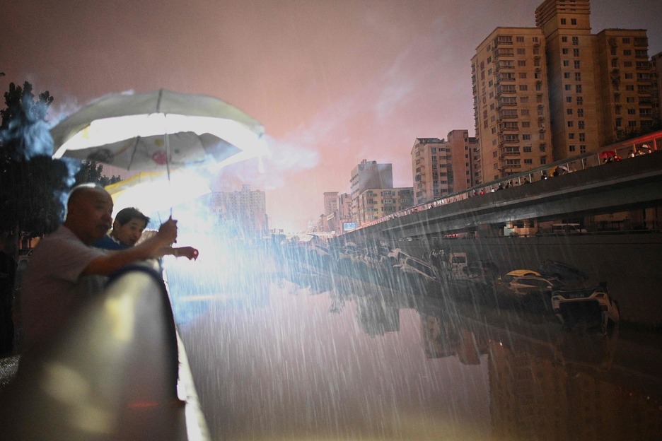Indar gutxiagoz bada ere, oraindik euria ari du Zhengzhou hirian. (Noel CELIS/AFP)