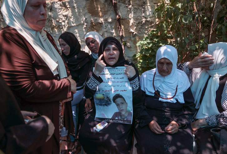 Ruba al-Tamimi porta un retrato de su hijo, muerto a tiros por el Ejército israelí. (Abbas MOMANI/AFP)