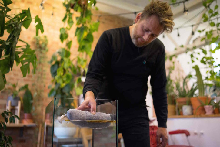 Fry Taylor muestra cómo utilizar el pelo cortado como filtro anticontaminación para limpiar el agua. (Tolga AKMEN/AFP)