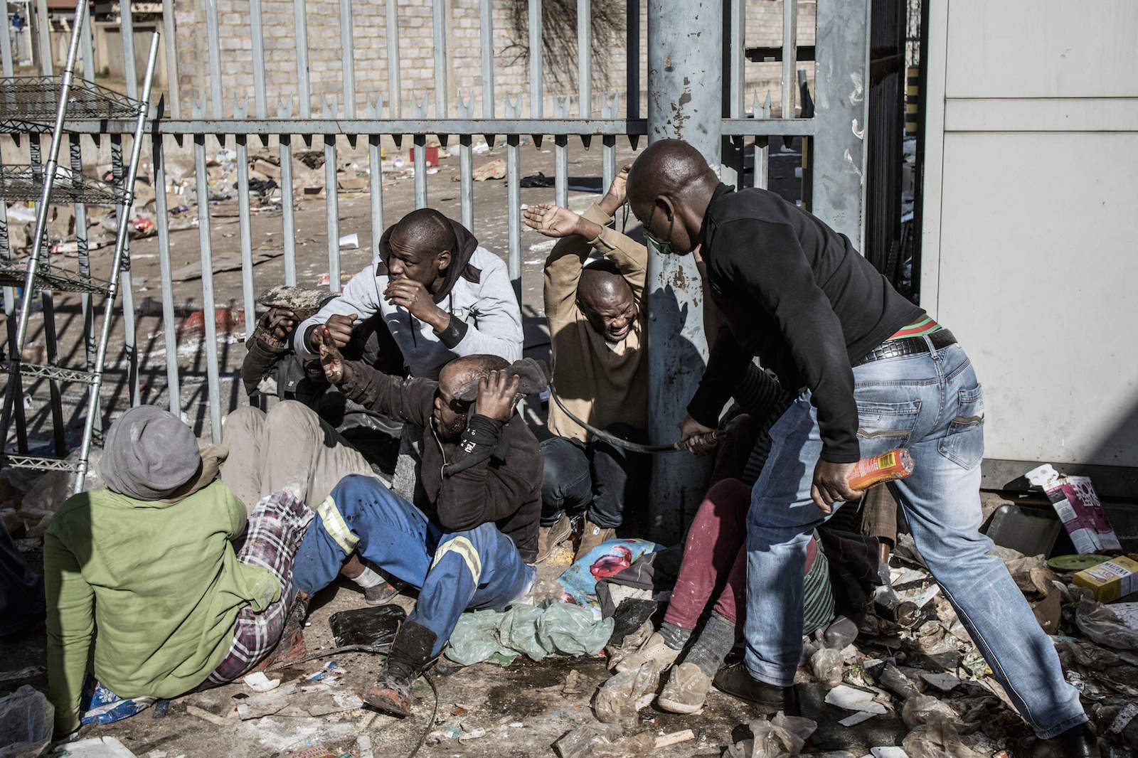 Un guarda de seguridad golpea a presuntos saqueadores. (Marco LONGARI/AFP)