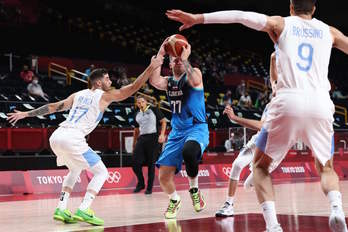 Luka Doncic se dispone a elevarse ante Vildoza y Brussino. (Thomas COEX/AFP)