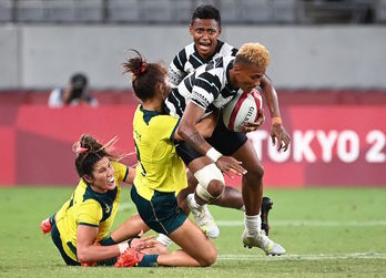 La defensa de Australia trata de defender a una atacante de Fiji. (GREG BAKER / AFP) 