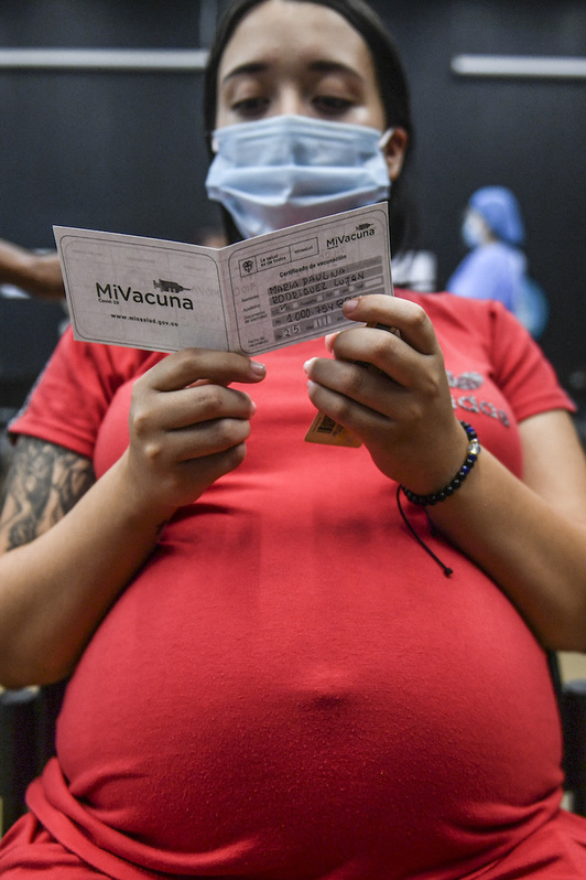 Una mujer embarazada lee el prospecto de la vacuna en Colombia. (Joaquín SARMIENTO/AFP)