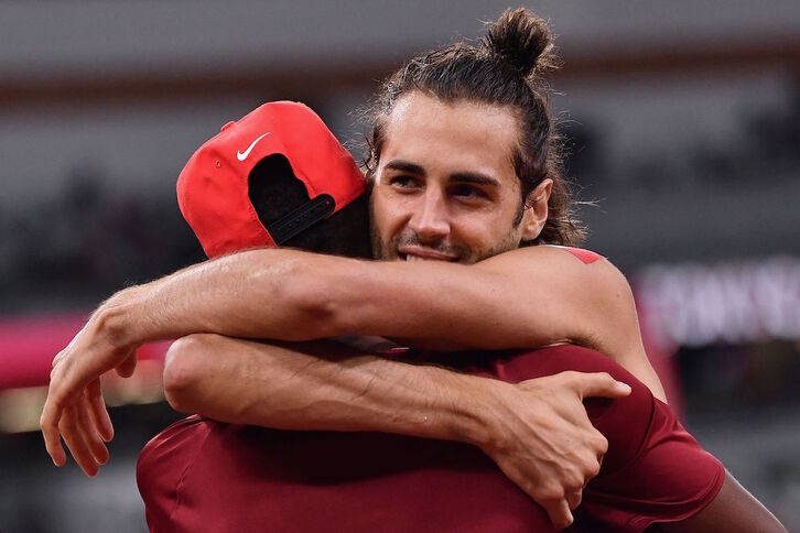 Barshim –de espaldas– y Tamberi se abrazan tras consensuar compartir el oro olímpico. (Ben STANSALL/AFP) 