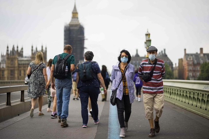 Personas con mascarilla pasean por uno de los puentes de Londres. (Tolga AKMEN/AFP)