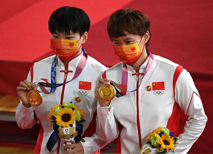 Las ciclistas Zhong Tianshi y Bao Shanju en el podio de Tokio 2020 con la medalla de oro. (Greg BAKER / AFP)