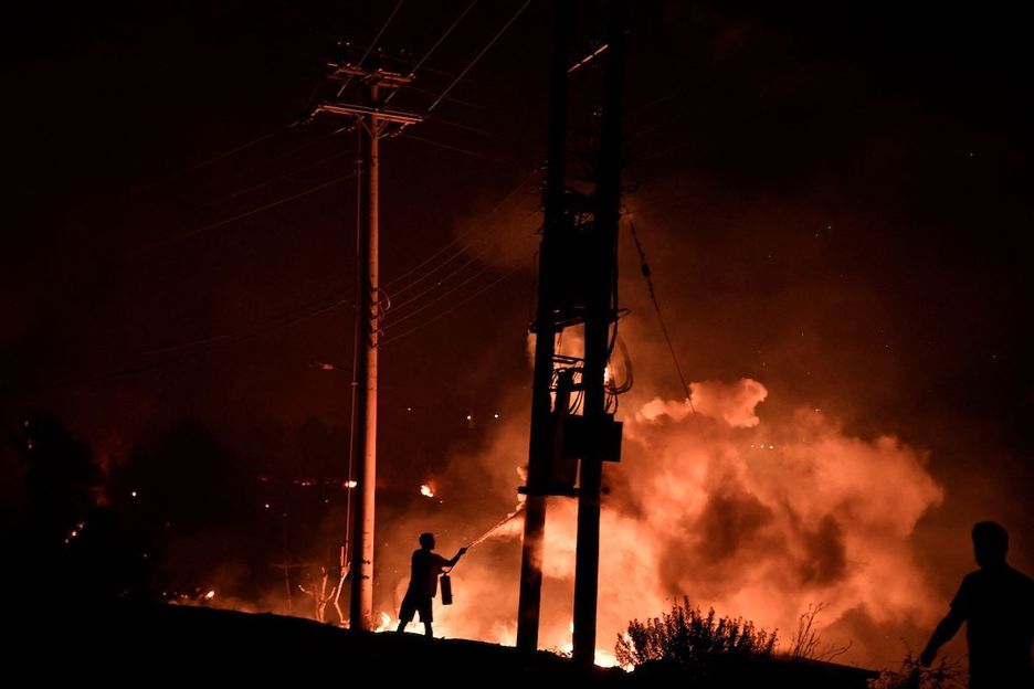 Una persona lucha contra las llamas en Grecia (Louisa GOULIAMAKI / AFP)