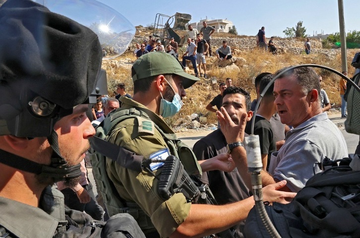 Palestinos que están viendo cómo sus viviendas son demolidas por Israel se encaran a soldados israelíes en Sair, al noreste de Hebrón, en la Cisjordania ocupada, este 5 de agosto. (Hazem BADER | AFP)